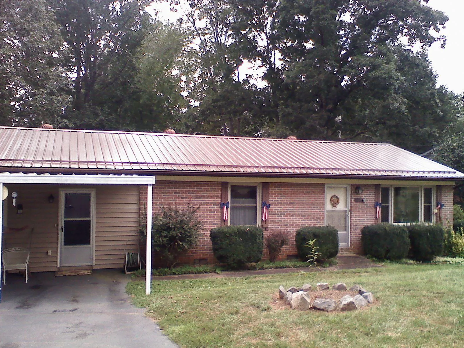 Bronze metal roof and carport on a brick ranch home — Roof Repair work by our crew in Yeagertown